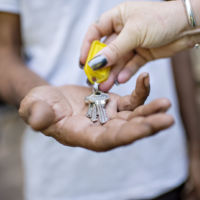 House keys being placed into an outstretched hand