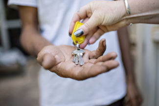 House keys being placed into an outstretched hand